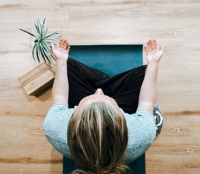 woman in black shirt and gray pants sitting on brown wooden bench
